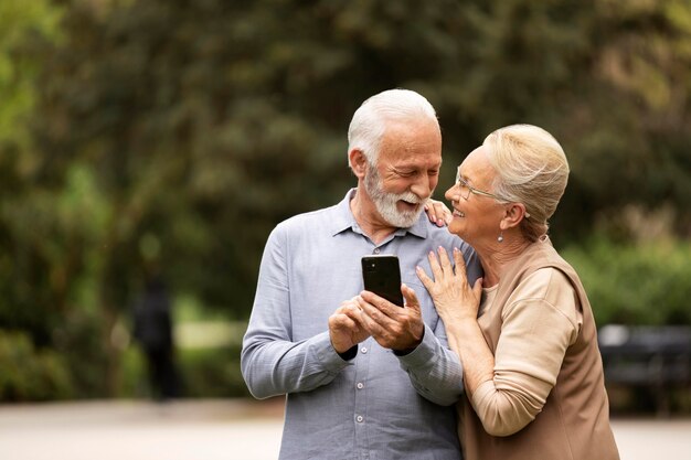 Foto grátis casal de tiro médio com telefone