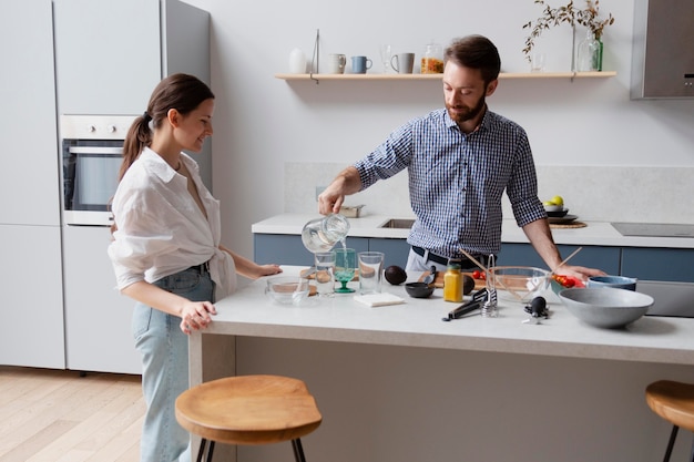 Casal de tiro médio cozinhando juntos