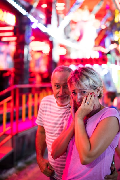 Casal de tiro médio no parque de diversões