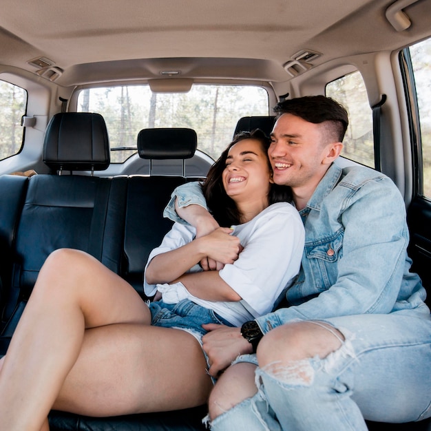 Casal de tiro médio se abraçando no carro