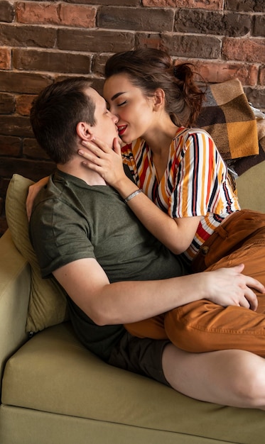 Foto grátis casal de tiro médio se beijando no sofá