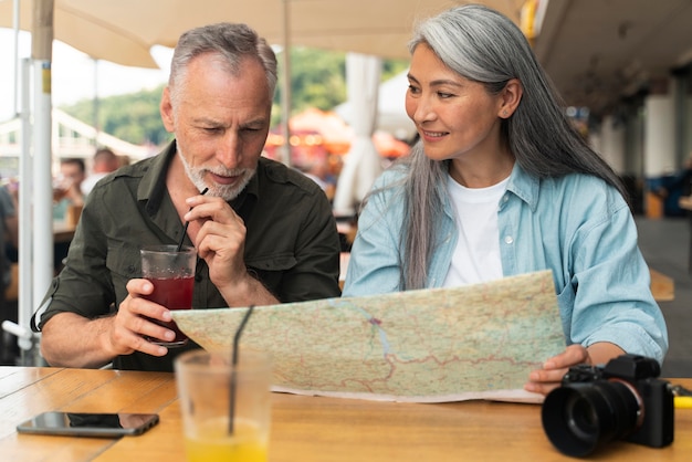 Foto grátis casal de tiro médio segurando mapa