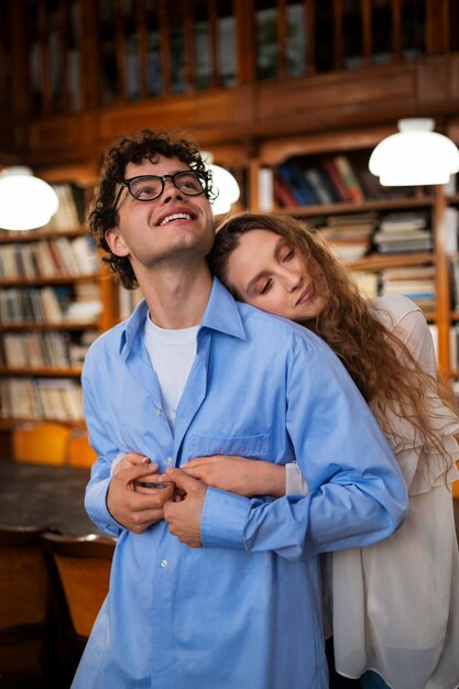 Foto grátis casal de tiro médio tendo um encontro na livraria