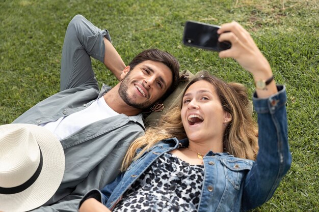 Casal de tiro médio tirando fotos