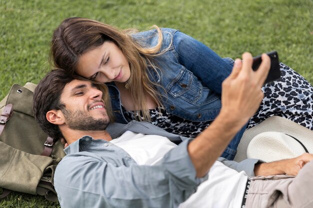 Casal de tiro médio tomando selfie
