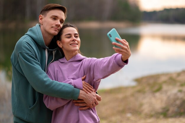 Casal de tiro médio tomando selfie