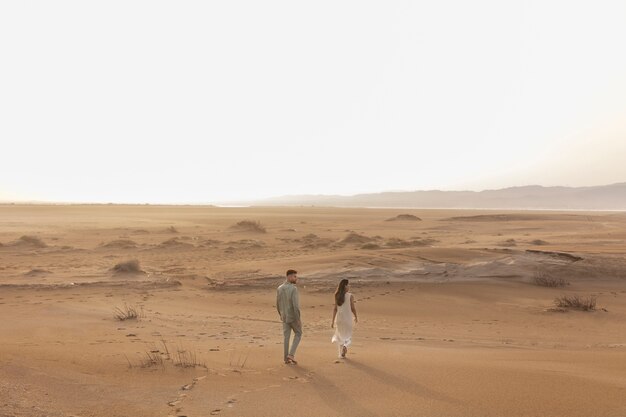 Casal de tiro no escuro andando no deserto