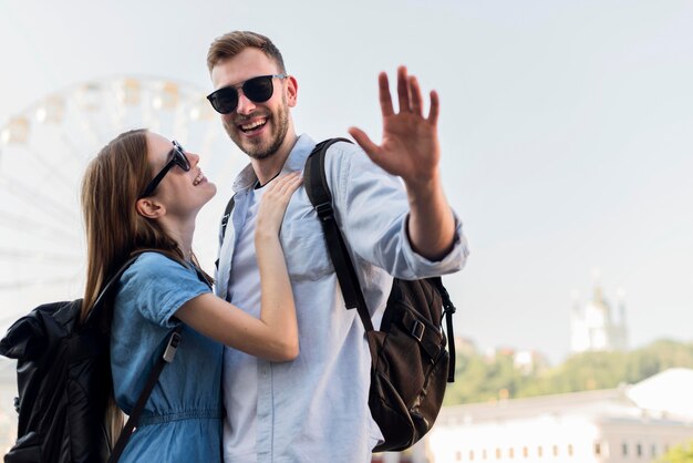 Casal de turista com homem acenando