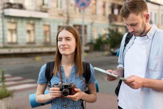 Casal de turista segurando a câmera e mapa