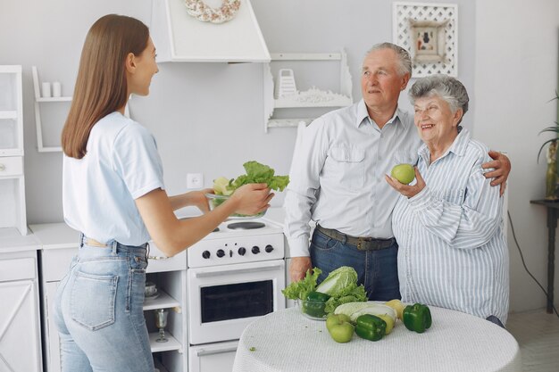 Casal de velhos em uma cozinha com jovem neta