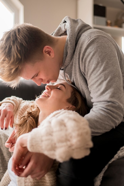 Foto grátis casal de vista lateral em casa beijando