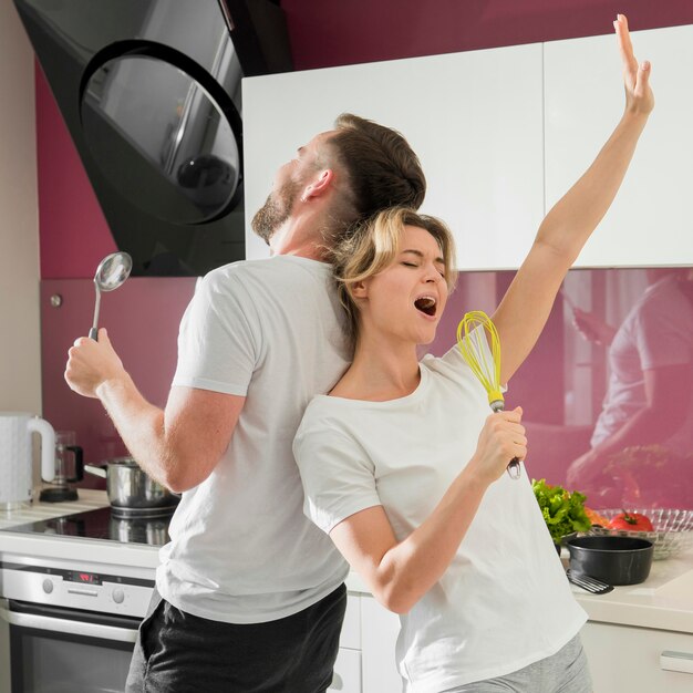 Casal dentro de casa cantando na cozinha juntos