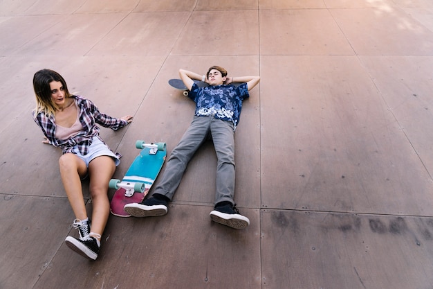 Casal do patinador deitado na metade do tubo