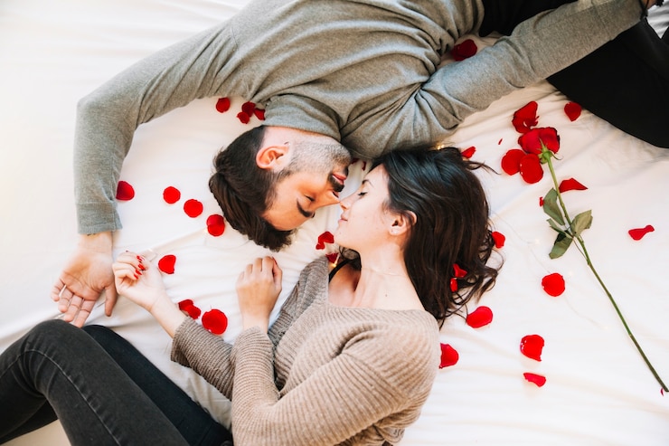 Foto grátis casal dormindo em pétalas de rosa