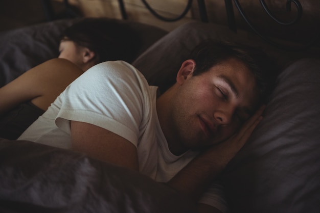 Casal dormindo na cama do quarto