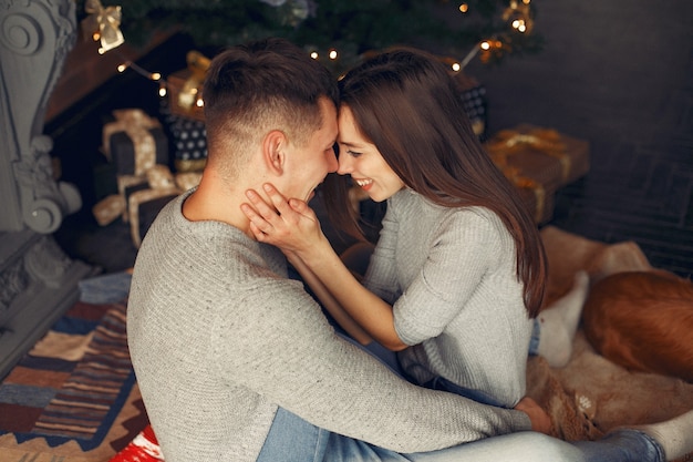 Casal elegante em casa perto da árvore de natal