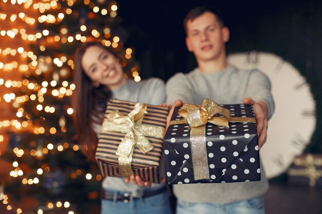 Casal elegante em casa perto da árvore de natal