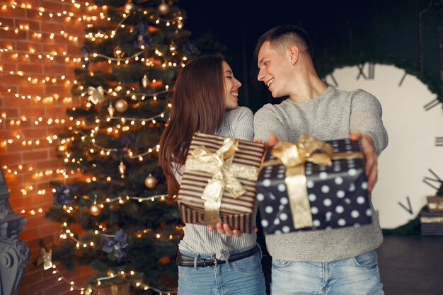 Casal elegante em casa perto da árvore de natal