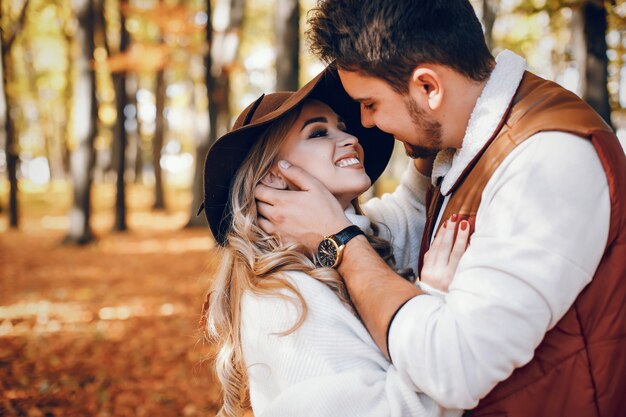 Casal elegante em um parque ensolarado de outono