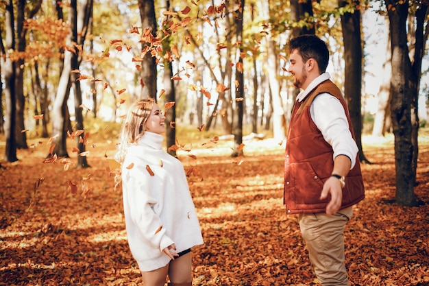 Foto grátis casal elegante em um parque ensolarado de outono