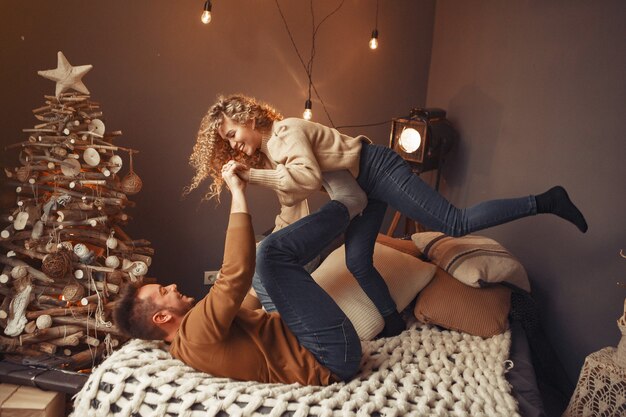 Casal elegante sentado em casa perto da árvore de natal