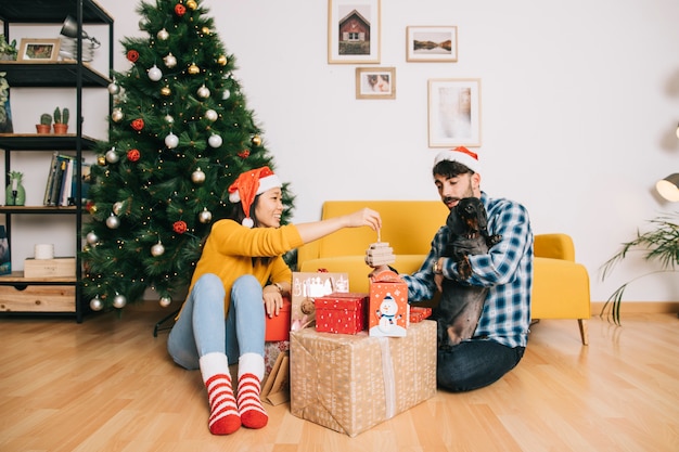 Casal em casa com caixas de presente