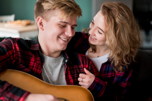 Casal em casa com guitarra