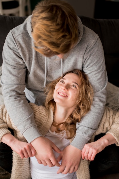 Casal em casa sorrindo um ao outro