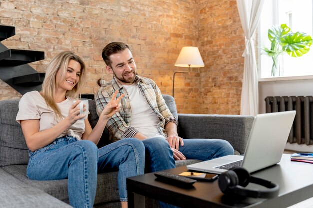 Casal em casa tendo videochamada com a família