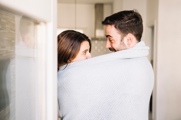 Foto grátis casal em cobertor olhando um para o outro