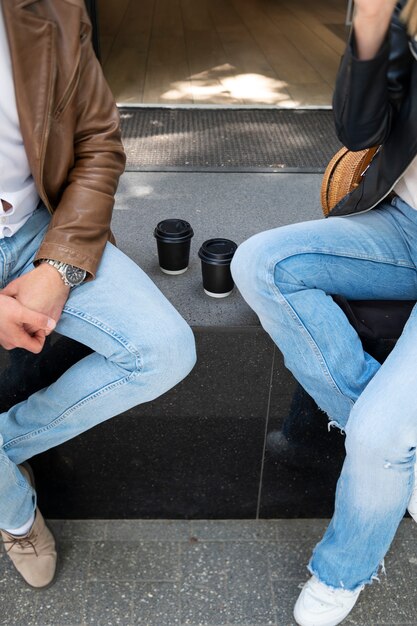 Casal em jaquetas de couro sintético tomando café juntos ao ar livre