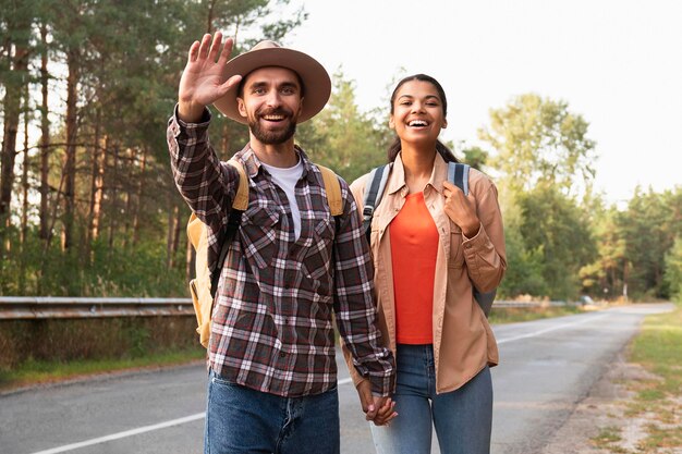 Casal em plano médio cumprimentando alguém durante a viagem