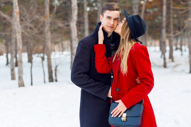 Casal em roupas de inverno, posando em um dia nevado