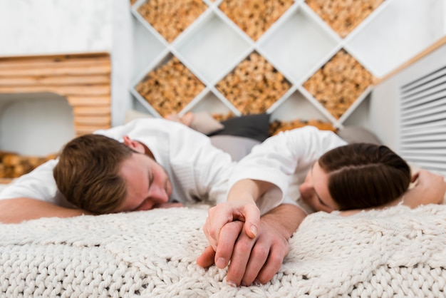 Casal em roupões dormindo na cama