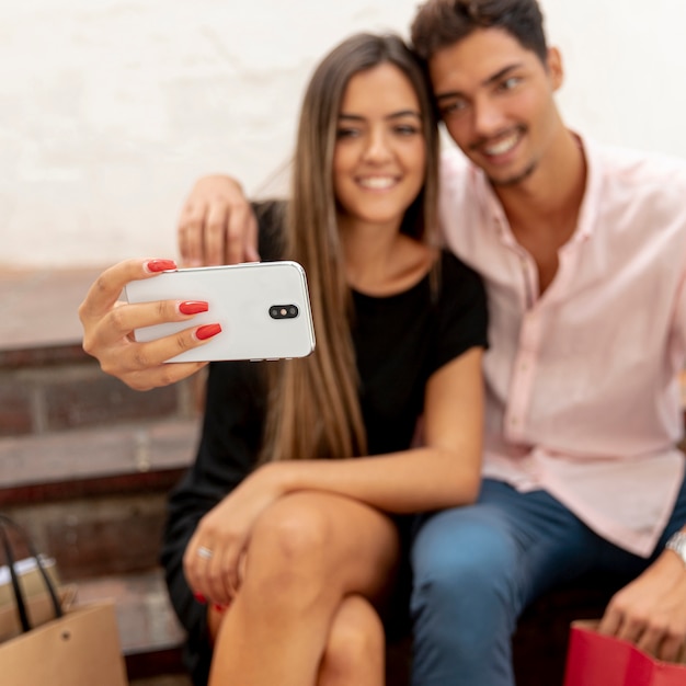 Casal embaçado tomando selfies no shopping