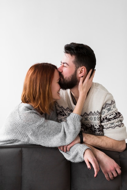 Foto grátis casal encostado no sofá e beijar