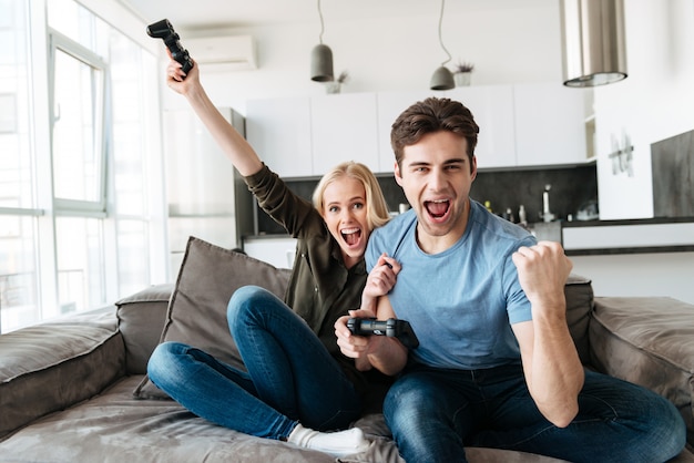 Casal engraçado jogando videogame e olhando a câmera