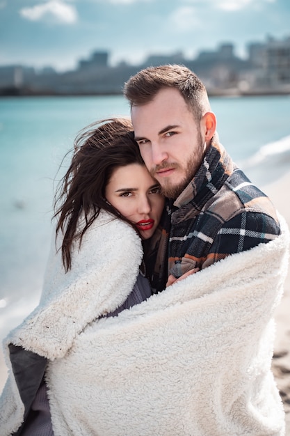 Casal está de pé na praia e posando