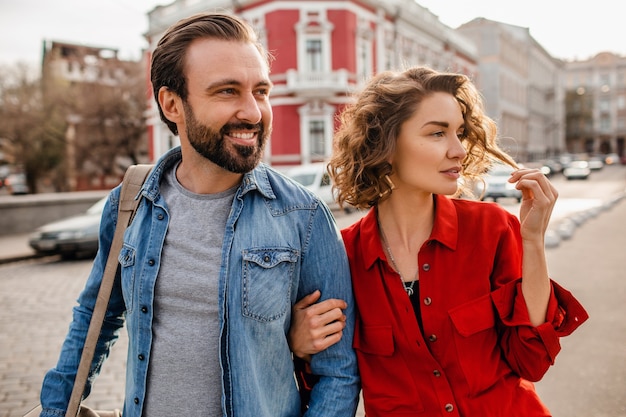 Casal estiloso apaixonado caminhando se abraçando na rua em uma viagem romântica