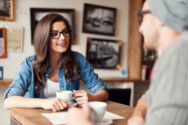 Casal estiloso conversando em um café