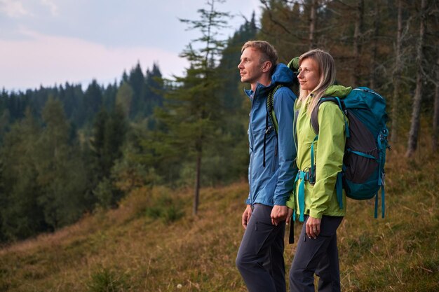 Casal familiar de viajantes caminhando nas montanhas