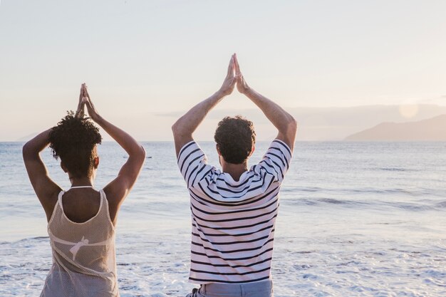 Casal fazendo exercício de ioga na praia