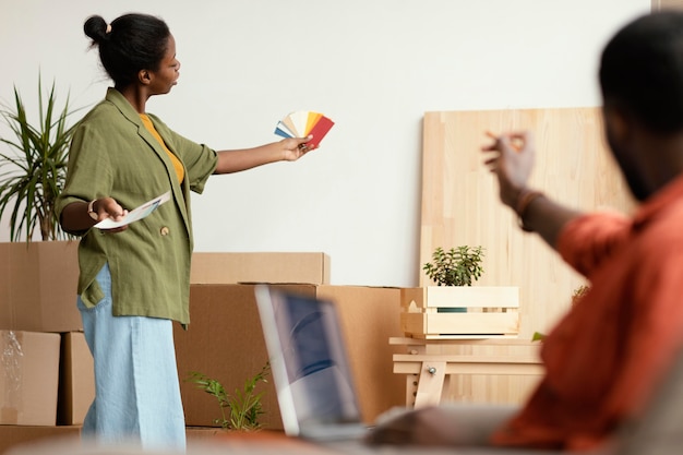 Casal fazendo planos para reformar a casa usando laptop e paleta de cores