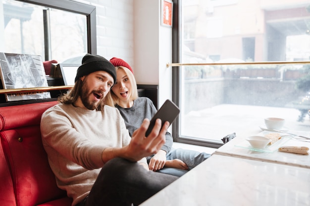 Casal fazendo selfie no café