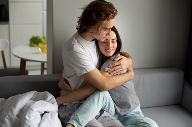 Casal feliz abraçando no sofá