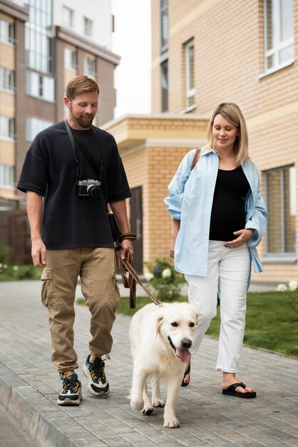 Casal feliz andando com o cachorro