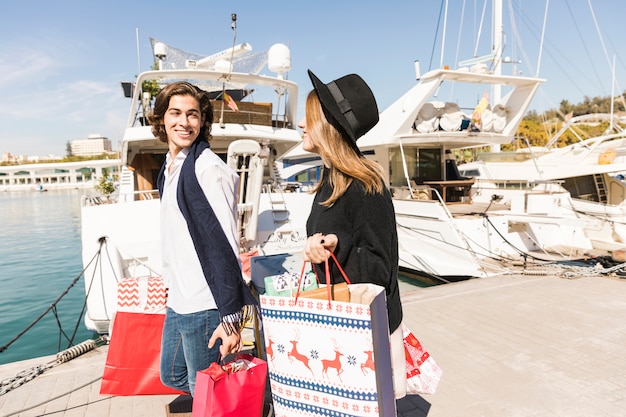 Casal feliz andando com sacolas de compras