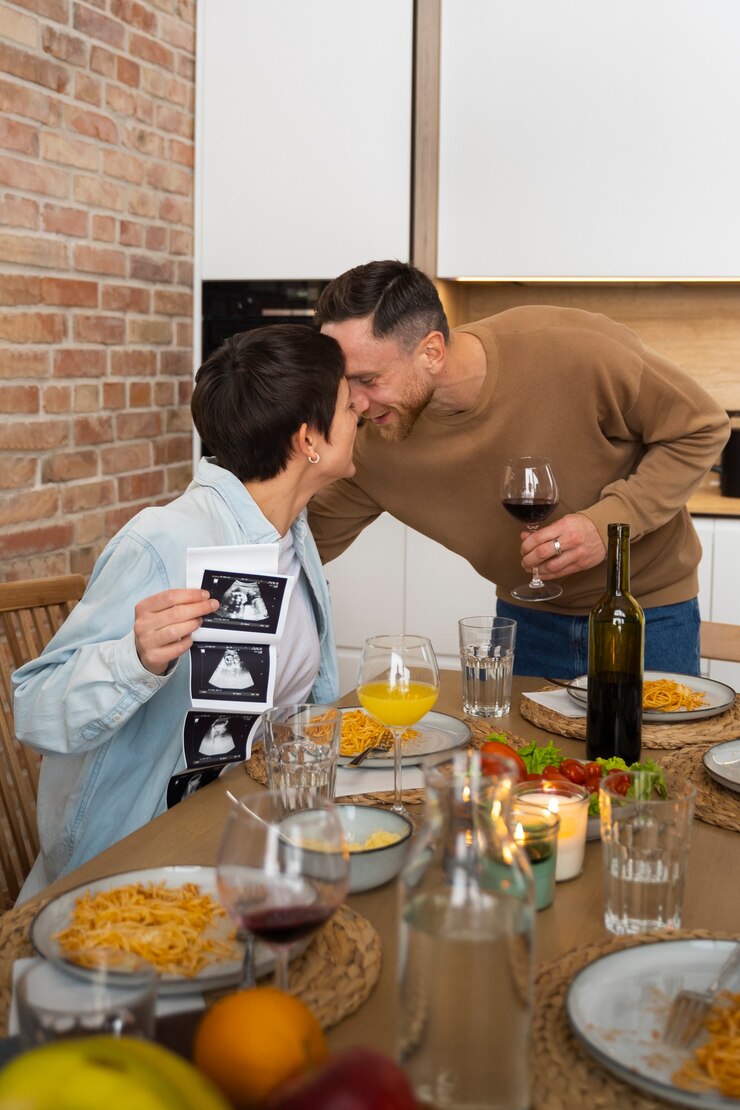 Foto grátis casal feliz anunciando gravidez em jantar com amigos