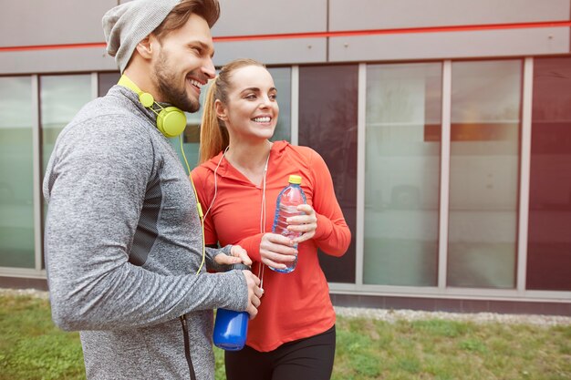 Casal feliz bebendo água após o exercício