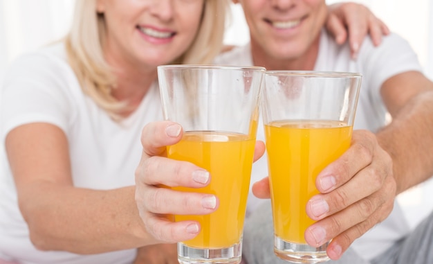 Casal feliz close-up com copos de suco